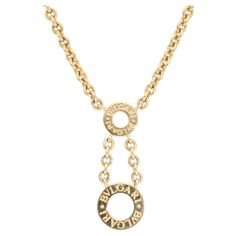 A stylish vintage Bulgari double circles necklace in 18k yellow gold. From the 'Bvlgari Bvlgari' collection, the necklace is composed of two circles engraved with the BVLGARI logo around the open circles. The circles are connected by two Bulgari chains that seamlessly continue as the necklace, which can be fastened with a secure lobster clasp. Due to the size and style, the necklace could be paired with various jewellery styles and worn for many occasions! It is a timeless design with a stylish Future Accessories, Vintage Bulgari, Bvlgari Logo, Double Circle Necklace, Bulgari Jewelry, Abstract Pendant, Bar Pendant Necklace, Drop Pendant Necklace, Circle Diamond