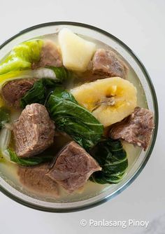 a bowl filled with meat and vegetables on top of a table