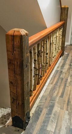 a wooden banister sitting on top of a hard wood floor next to a wall