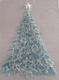 a frosted glass christmas tree on the ground