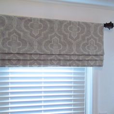 a window with roman shades in a room