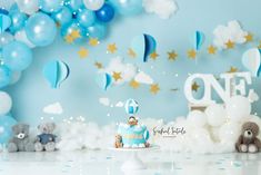 a blue and white birthday cake surrounded by balloons