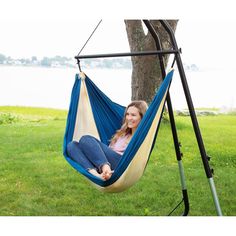 a woman sitting in a hammock hanging from a tree