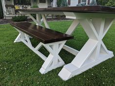 a wooden bench sitting on top of a green grass covered field next to a house