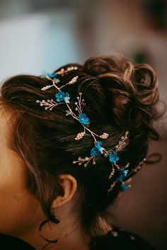 a woman wearing a blue flowered hair comb