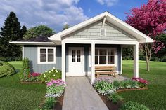 a small house with flowers around it and a bench in the front yard on the grass