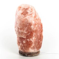 a large pink rock sitting on top of a wooden base