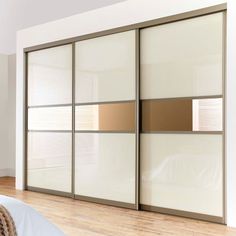 an empty bedroom with white and brown closet doors on the wall next to a bed