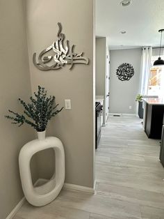 a white urinal sitting on the side of a wall next to a plant