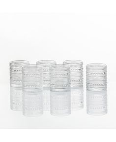 six clear glass tumblers sitting side by side