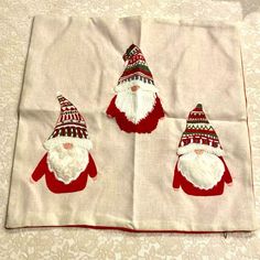 three christmas gnomes on a white table cloth