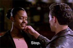 a man helping a woman put on her necklace with the words stop in front of him