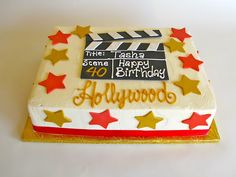 a birthday cake with stars and a clapperboard on the top that says hollywood