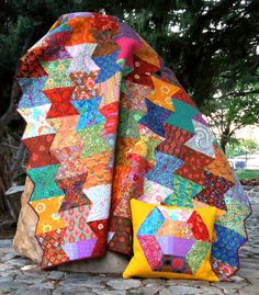 a colorful quilt sitting on top of a rock