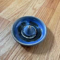 a blue bowl sitting on top of a wooden floor