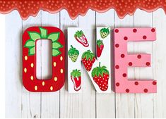 the word e is made up of wooden letters with strawberries on them and polka dots