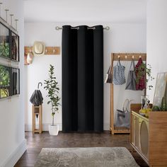 a living room filled with furniture and lots of black drapes on the windowsill