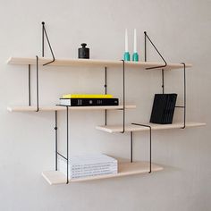 three shelves with books, candles and other items on them in the shape of shelving