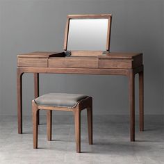 a wooden desk with a mirror and stool