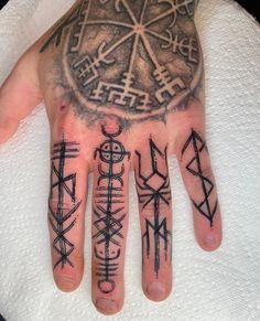 a person's hand with tattoos on it and other symbols around the palm area