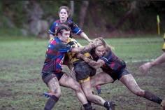 a group of young men playing a game of frisbee on a muddy field