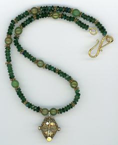 "Emerald green faceted crystal glass sparkles next to moss green/gold glass and gold vermeil accents. At the center of the necklace is a classic Balinese gold vermeil pendant with gorgeous granulation. The necklace is finished with a beautiful gold vermeil \"S\" clasp. (2001-38A) * Matching earrings are available as shown. If interested in purchasing both items, please contact me for special set pricing. TO SEE ALL OF MY UNIQUE JEWELRY DESIGNS, PLEASE VISIT https://UniqueCherie.etsy.com Sign up Emerald Green Crystal, Bone Beads, Unique Jewelry Designs, Lovely Necklace, Gold Glass, Faceted Crystal, Balinese, Green Crystals, Moss Green