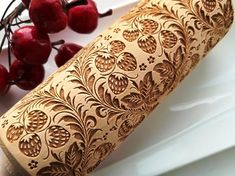 a knife and some cherries on a white plate with gold foiled paper in the shape of a scroll