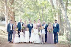 a group of people standing next to each other in front of trees