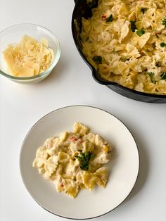 a white plate topped with food next to a skillet filled with macaroni and cheese