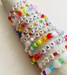 a stack of bracelets with letters and hearts on them sitting on top of a table