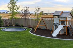 a backyard with a swing set, slide and artificial grass in the back yard area