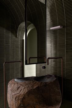 a large rock sitting under a mirror in a bathroom