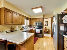 a kitchen with wooden cabinets and white counter tops, along with an island in the middle