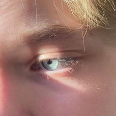 a close up of a person's face with the sun shining on their eyes