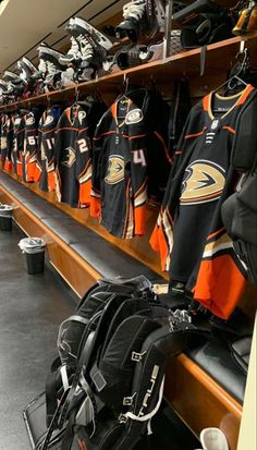 the locker room is full of hockey jerseys and backpacks for fans to wear on their team