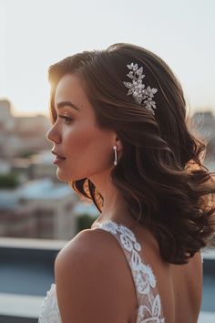 a woman in a wedding dress looking off into the distance with her hair blowing in the wind