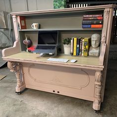 an old desk with a laptop on it and bookshelf in the back ground