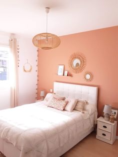 a white bed sitting in a bedroom next to a window