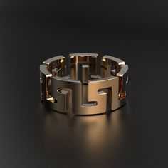 a gold and silver ring on a black surface with light coming from it's center