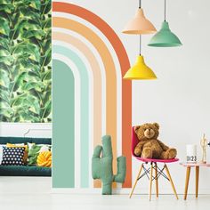 a teddy bear sitting on a chair in front of a rainbow wall mural