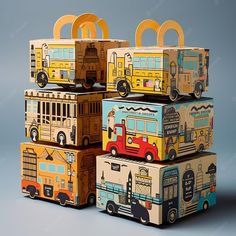 four boxes with different designs on them are stacked up in the shape of school buses