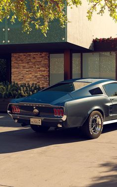 an old muscle car parked in front of a building