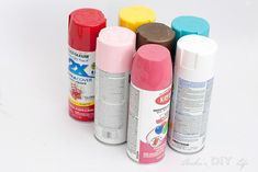 several different types of spray paint on a white surface