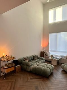 a living room filled with furniture next to a window and a wooden flooring area