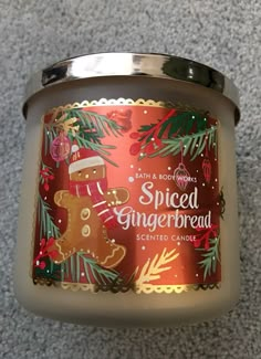 a candle that is on the ground with christmas decorations around it and a gingerbread design