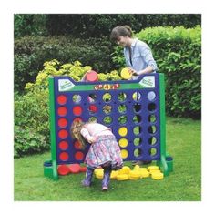 two children playing in the yard with giant connect - it - all game