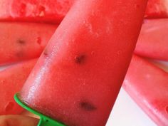 a close up of a piece of watermelon on a green toothpick