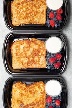 three black trays filled with french toast and berries next to yogurt sauce