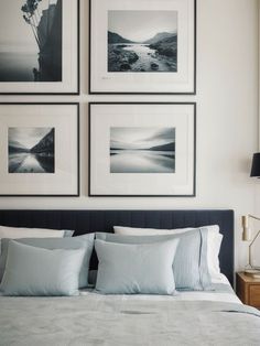 a bed with four framed pictures above it