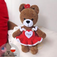 a brown teddy bear wearing a red dress with a heart on it's chest